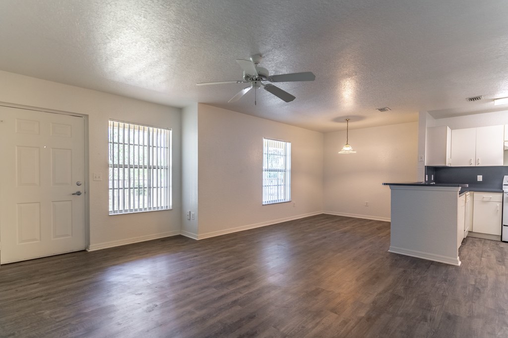 A room with a ceiling fan and wooden flooring.