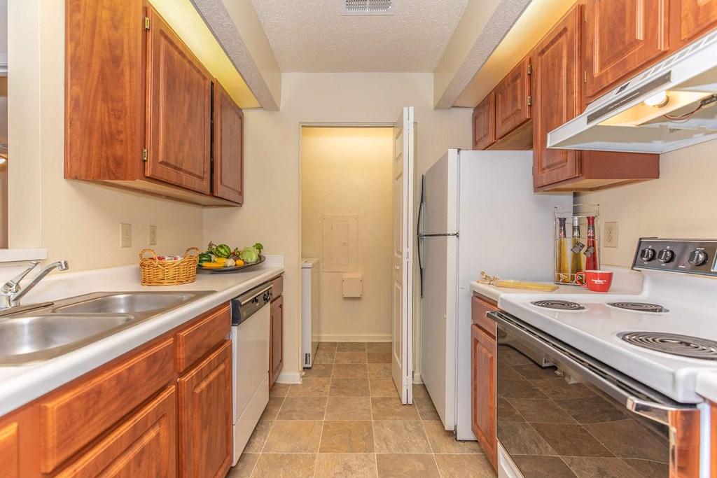 a kitchen with wood cabinets and white appliances at Arbors at Windsor Lake, South Carolina   
