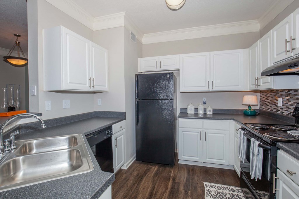 a kitchen with white cabinets and a black refrigerator at Carrington Place at Wildewood, Columbia  