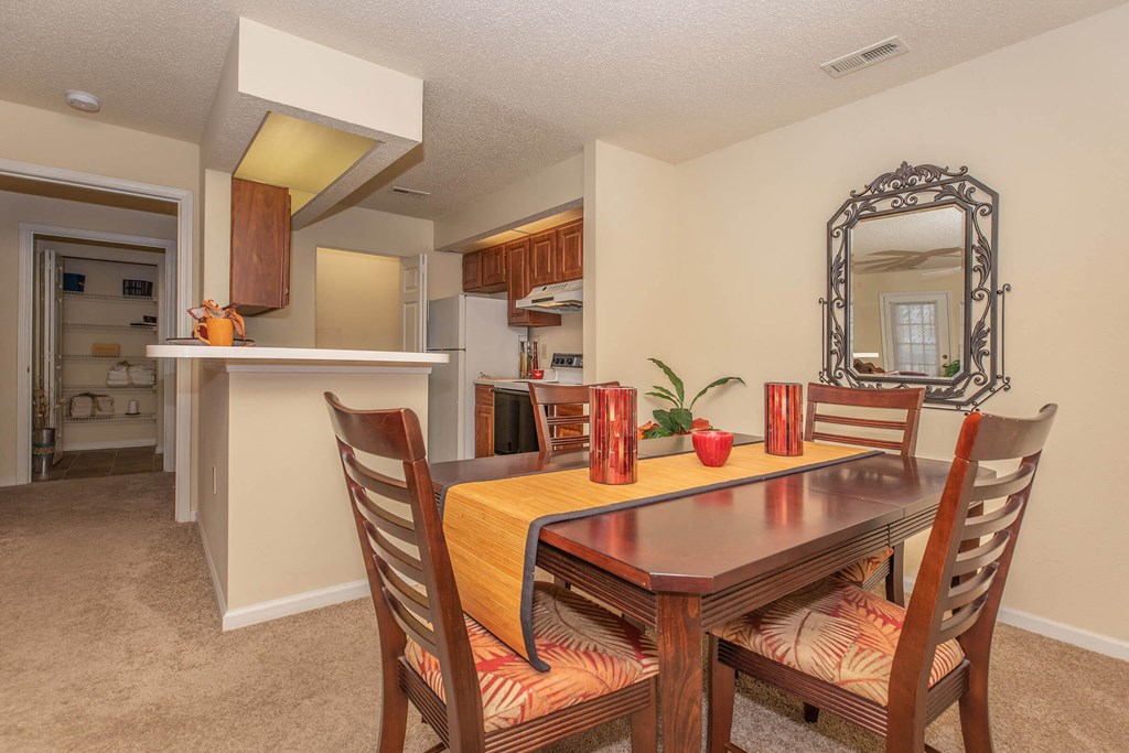 a dining area with a table and chairs and a kitchen in the background at Arbors at Windsor Lake, Columbia, 29223  