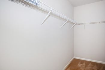 A white wall with a white shelf on it.