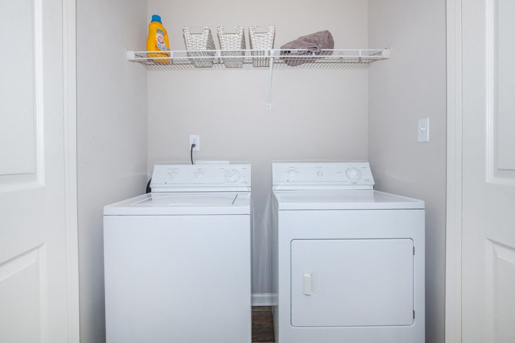 a small laundry room with two washes and a dryer at Carrington Place at Wildewood, Columbia South Carolina   