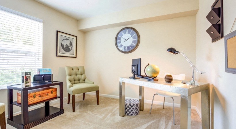 a home office with a large clock on the wall