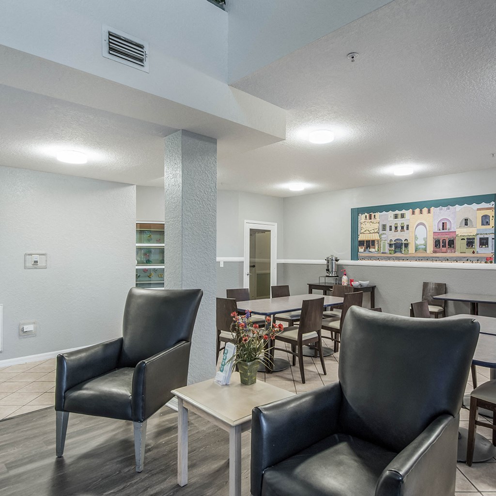 a common area with chairs and tables at the enclave at woodbridge apartments in sugar land