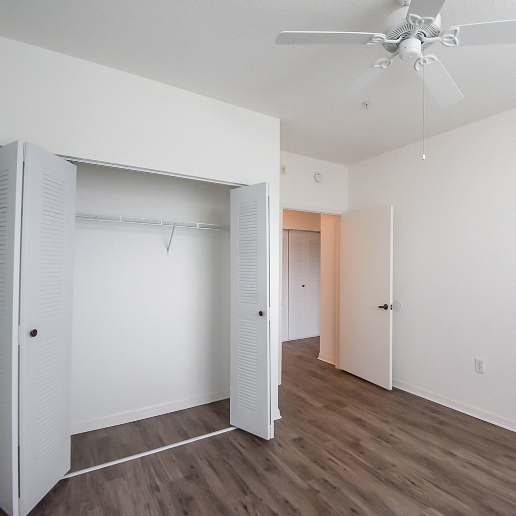a bedroom with a closet and a ceiling fan