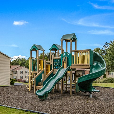a playground with three slides and a monkey bars