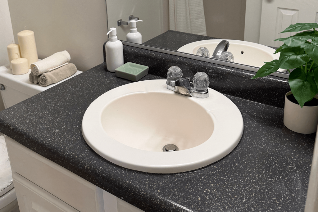 A bathroom sink with a black granite countertop.