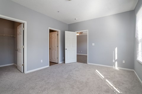a bedroom with two doors and a carpeted floor