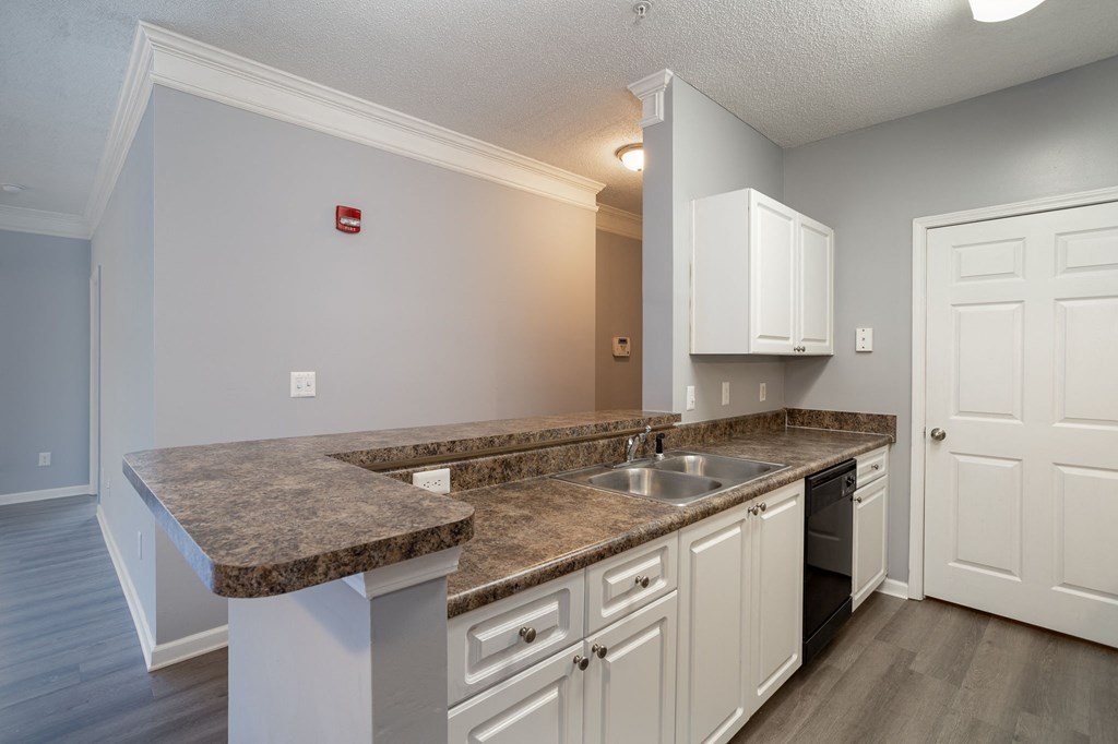 a kitchen with granite countertops and white cabinets