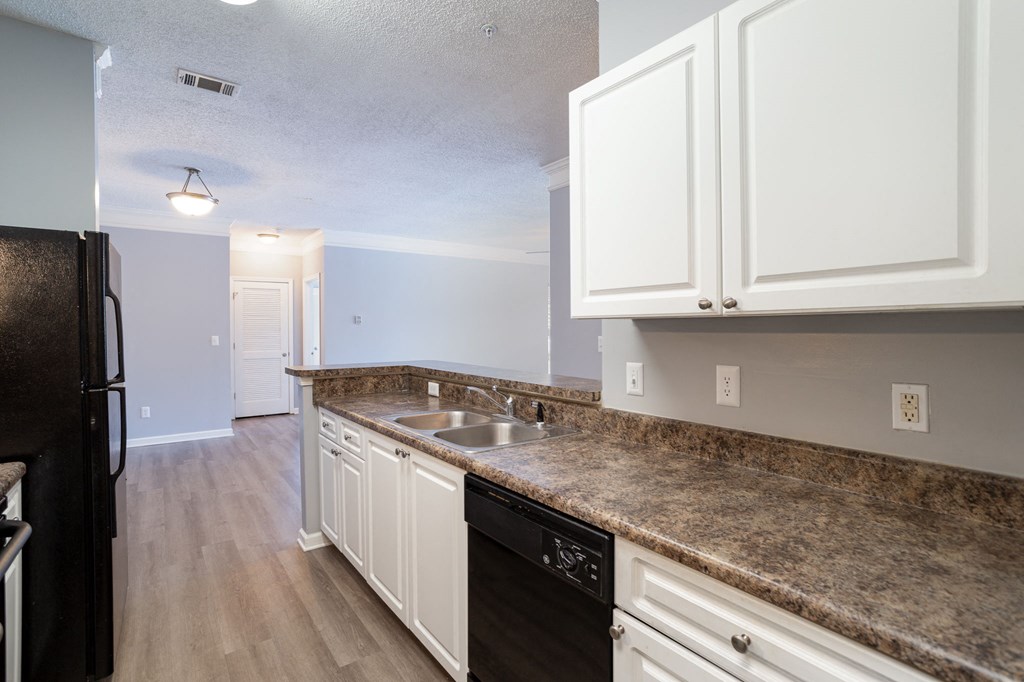 a kitchen with white cabinets and granite countertops