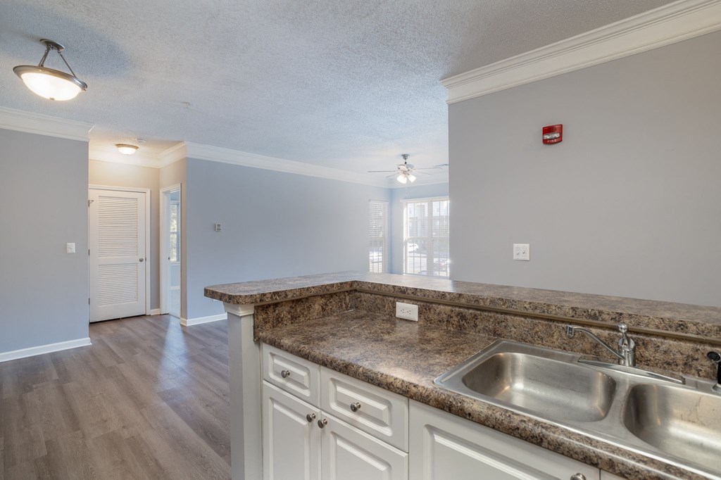 a kitchen with white cabinets and a granite counter top