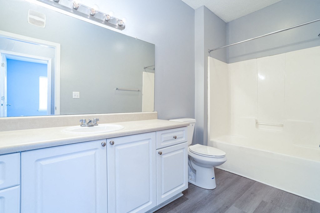 a bathroom with a white sink and toilet next to a white bathtub