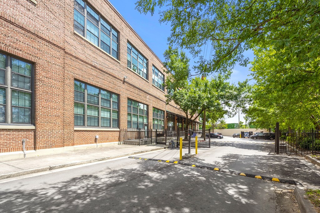 A red brick building with a black gate in front.