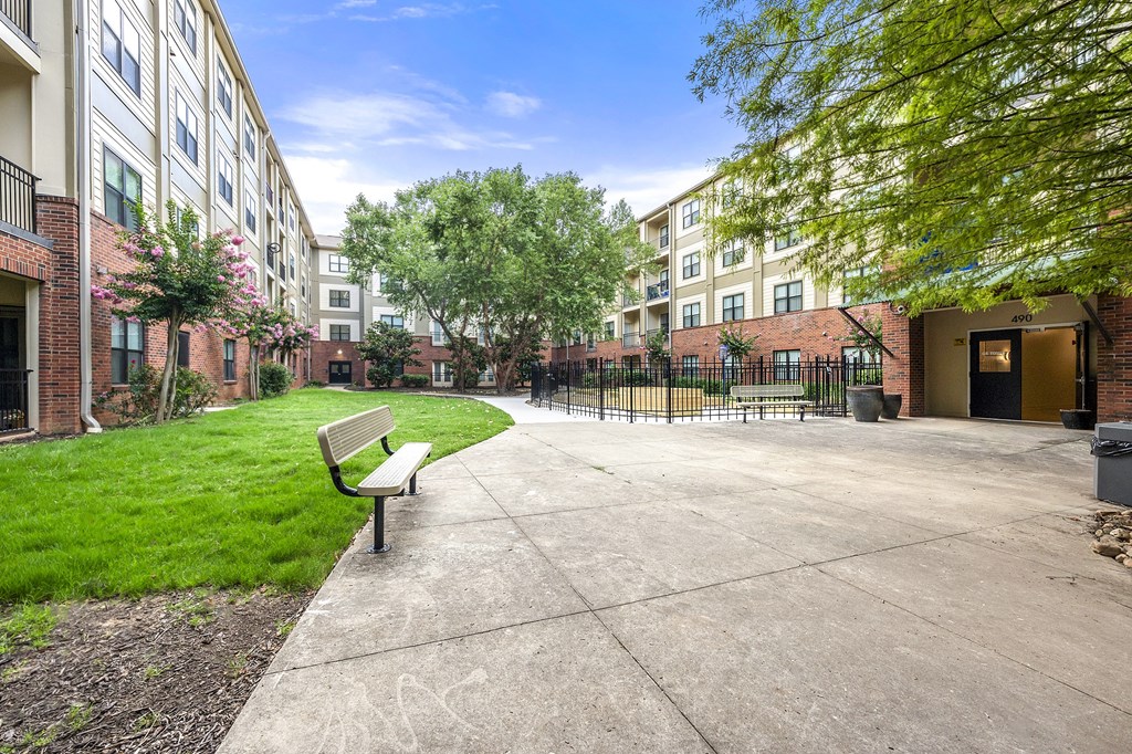 A bench is situated on a concrete area in front of a building.