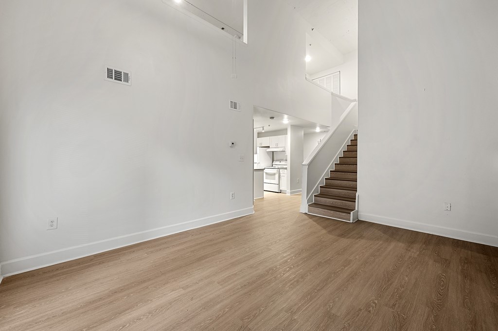 A room with wooden floors and a staircase.