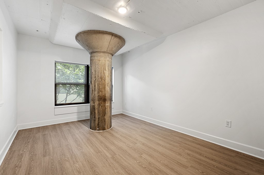 A room with a large column in the middle of it.