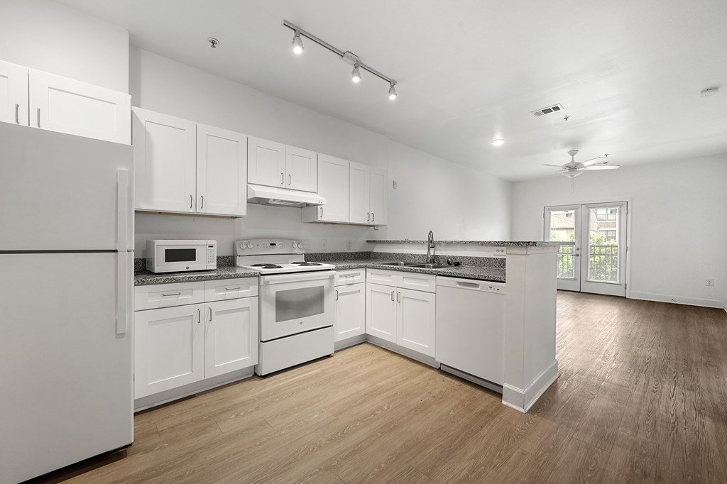 A kitchen with white appliances and cabinets.