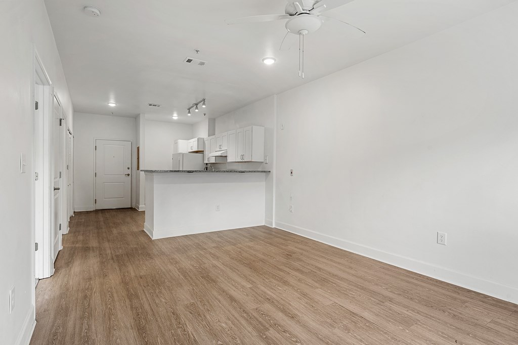 A room with a ceiling fan and wooden flooring.