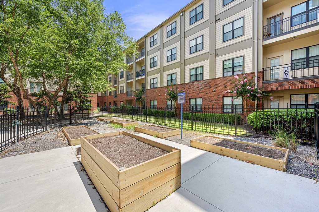 Apartment complex with a garden in front.