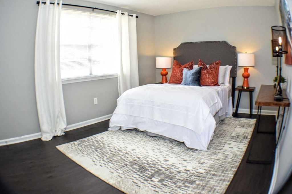 a bedroom with gray walls and a white bed with red and blue pillows at Brandywine Townhomes, Goose Creek