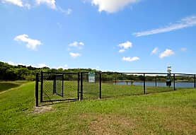 a fenced in area with a body of water in the background