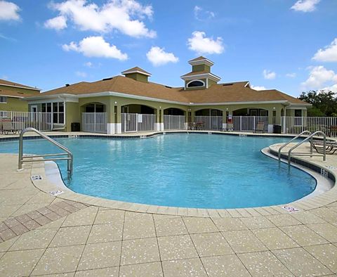 a large swimming pool in front of a resort style building