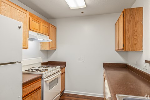 A kitchen with wooden cabinets and a white refrigerator.