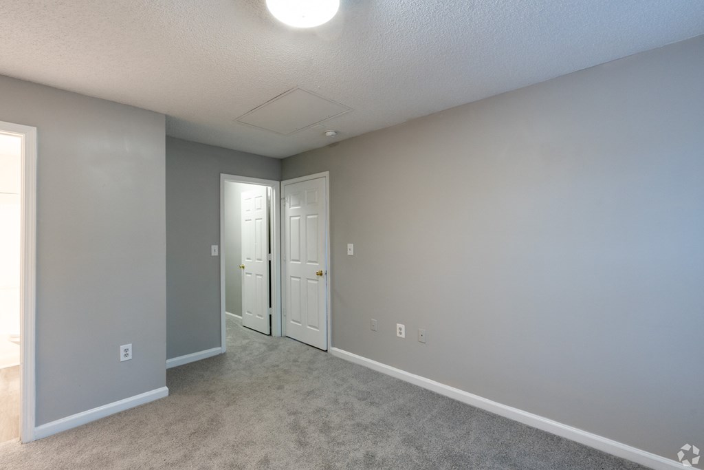 an empty room with two doors and a carpeted floor at Avon Crossings, Durham North Carolina