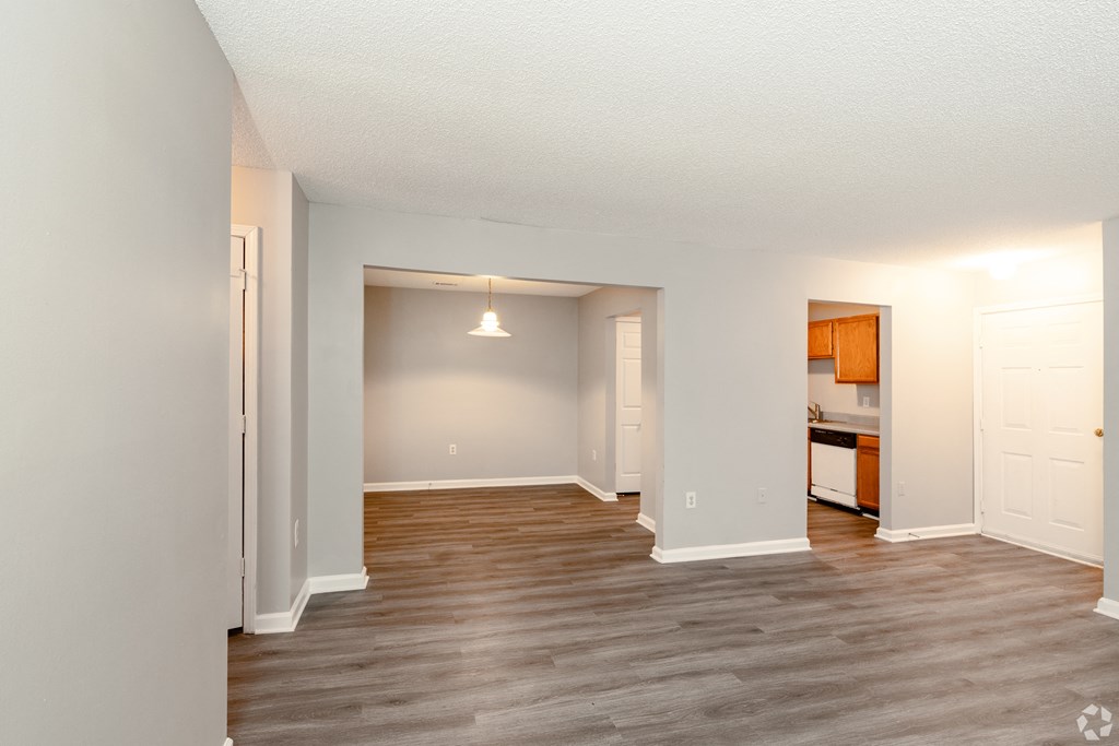 an empty living room with wood flooring and a kitchen at Avon Crossings, Durham North Carolina