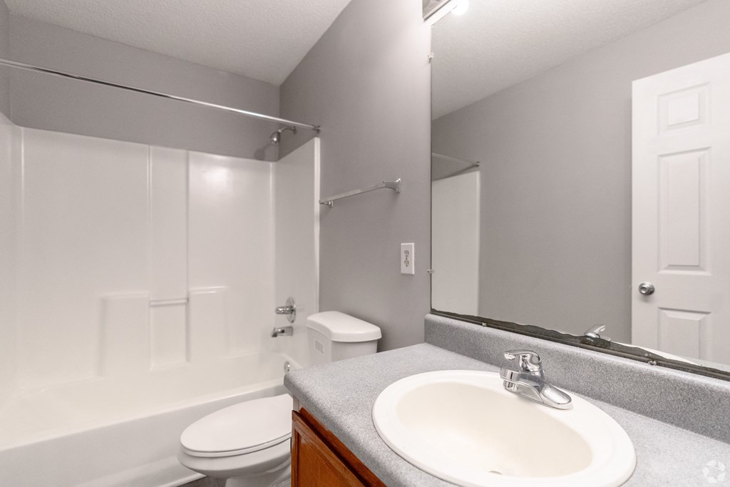 a bathroom with a mirror and a sink and a toilet at Avon Crossings, Durham, NC