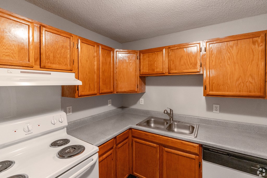 a kitchen with a stove and sink and wooden cabinets at Avon Crossings, Durham