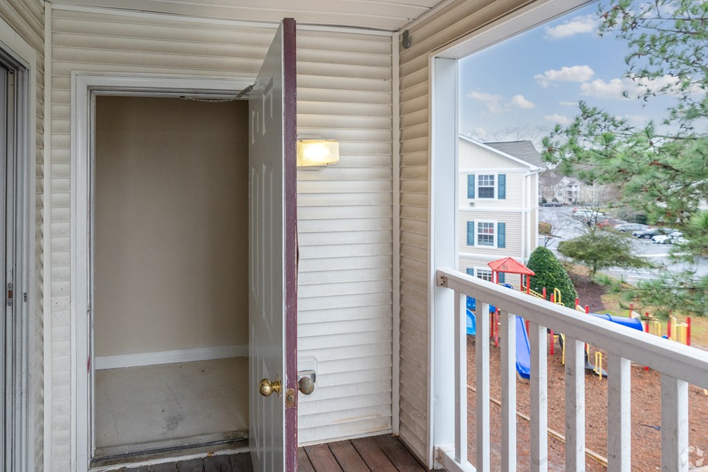 a door open to a balcony with a house in the background at Avon Crossings, Durham, NC