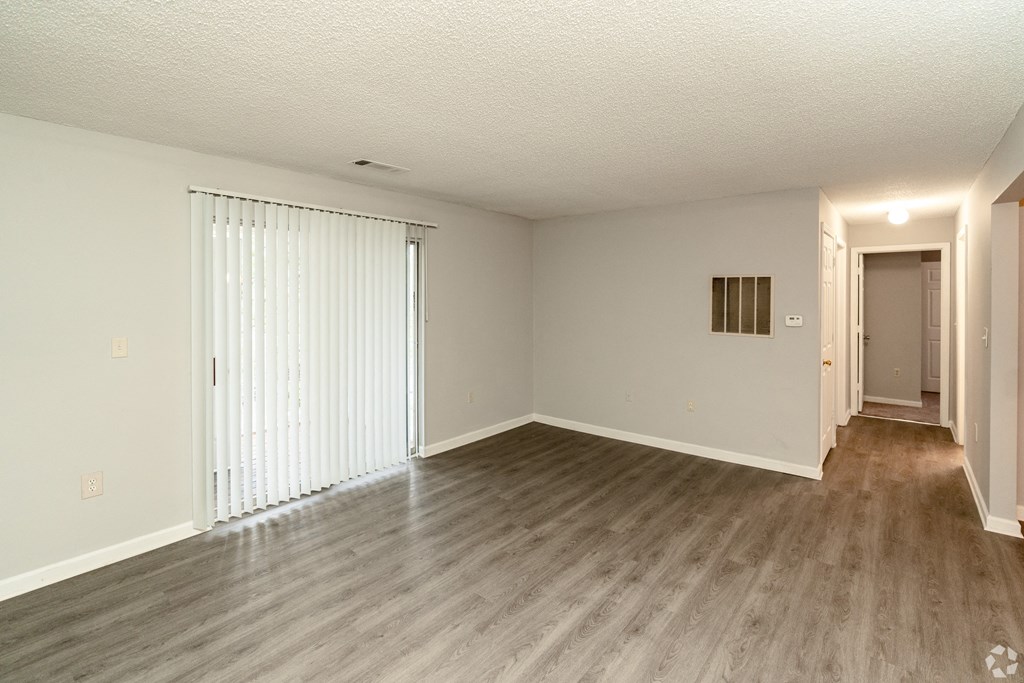 an empty living room with white walls and wood flooring at Avon Crossings, North Carolina, 27713