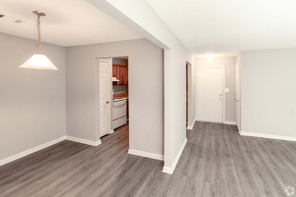 a renovated living room and kitchen with wood flooring and a door to the kitchen at Avon Crossings, Durham, 27713