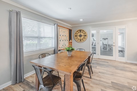 A dining room with a wooden table and chairs.