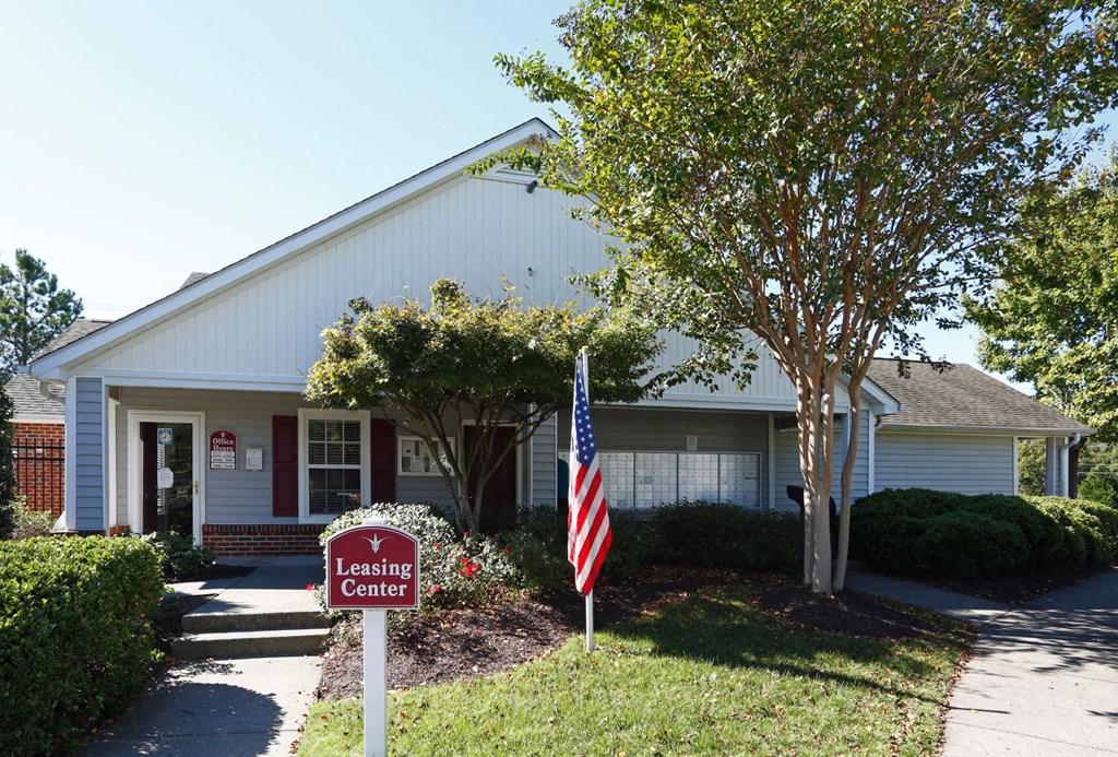 a house with an american flag and a leasing sign in front of it