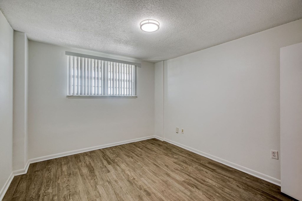 a bedroom with white walls and a window