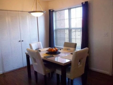 A dining room with a table and chairs.