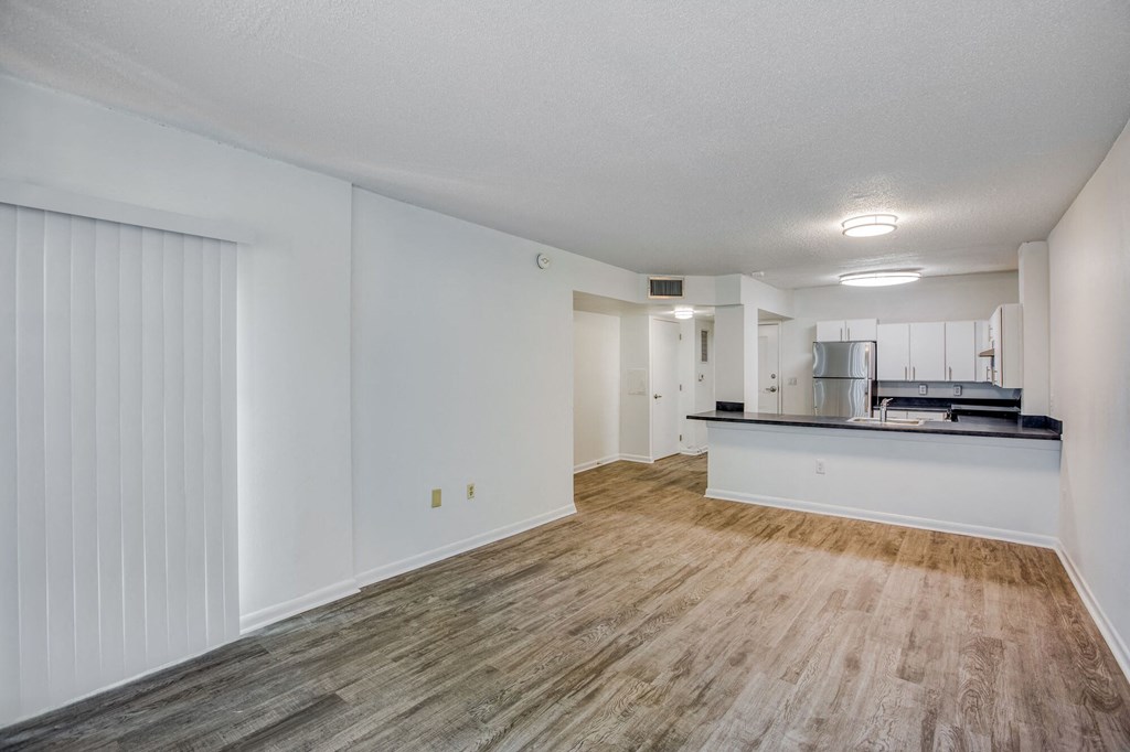 a living room with a kitchen in the background