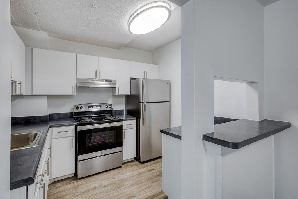 a kitchen with white cabinetry and stainless steel appliances