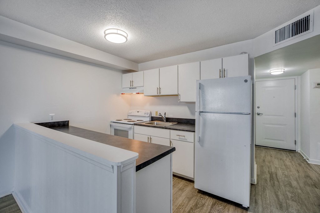 a kitchen with white cabinets and a white refrigerator