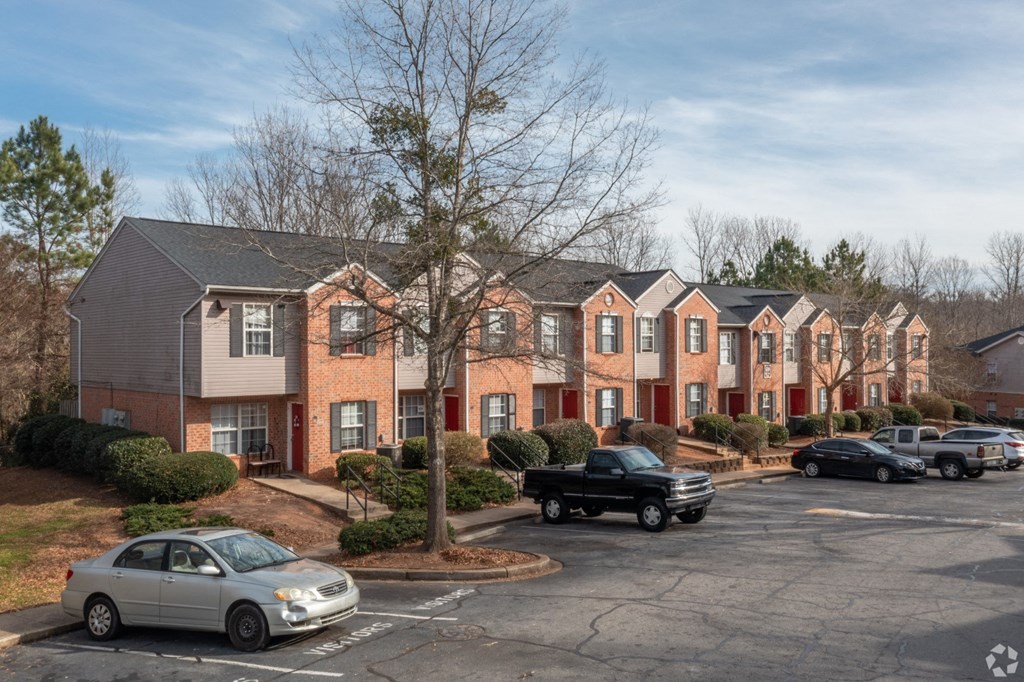 a row of apartment buildings with cars parked in a parking lot at Canaan Pointe, Greenville, 29607