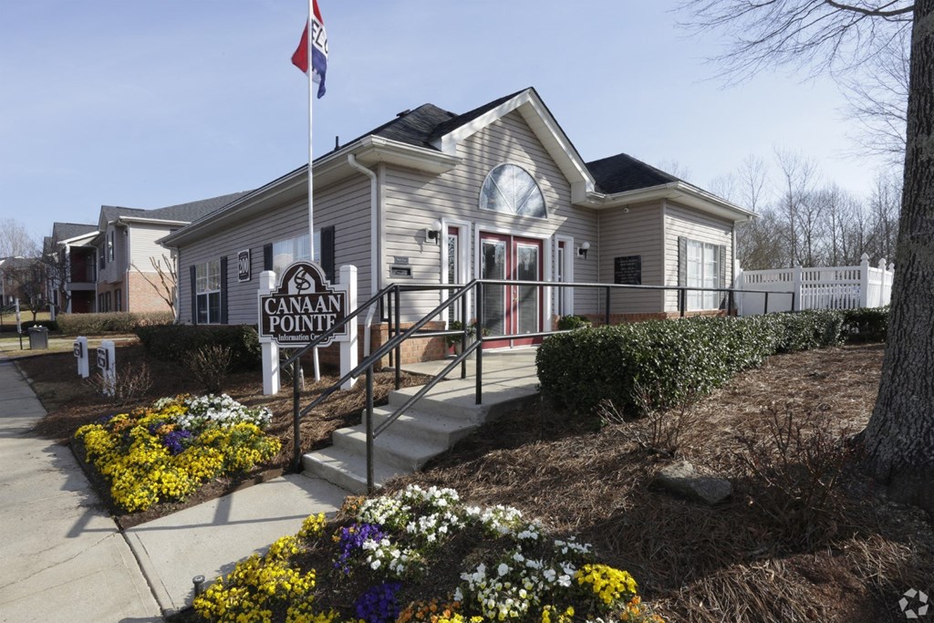 the front of a cream colored house with a flag and a sidewalk at Canaan Pointe, Greenville South Carolina