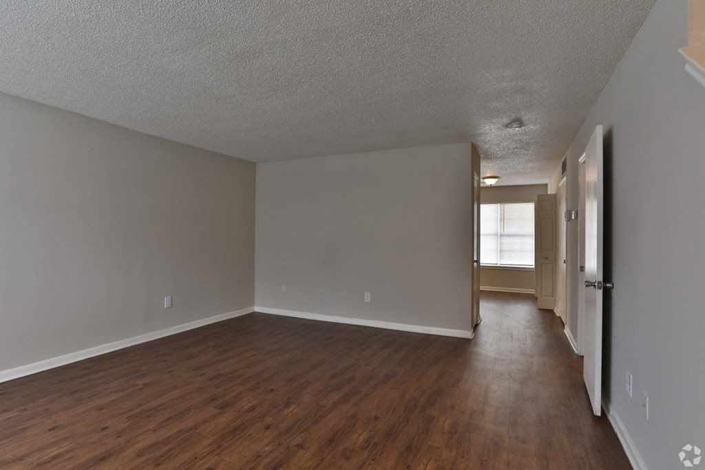 the living room and dining room of an apartment with wood flooring and grey walls at Canaan Pointe, South Carolina