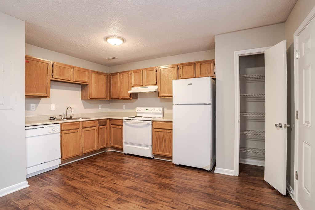 A kitchen with wooden cabinets and white appliances.