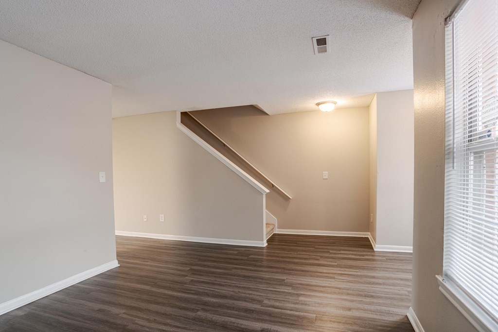 A room with wooden floors and a staircase.