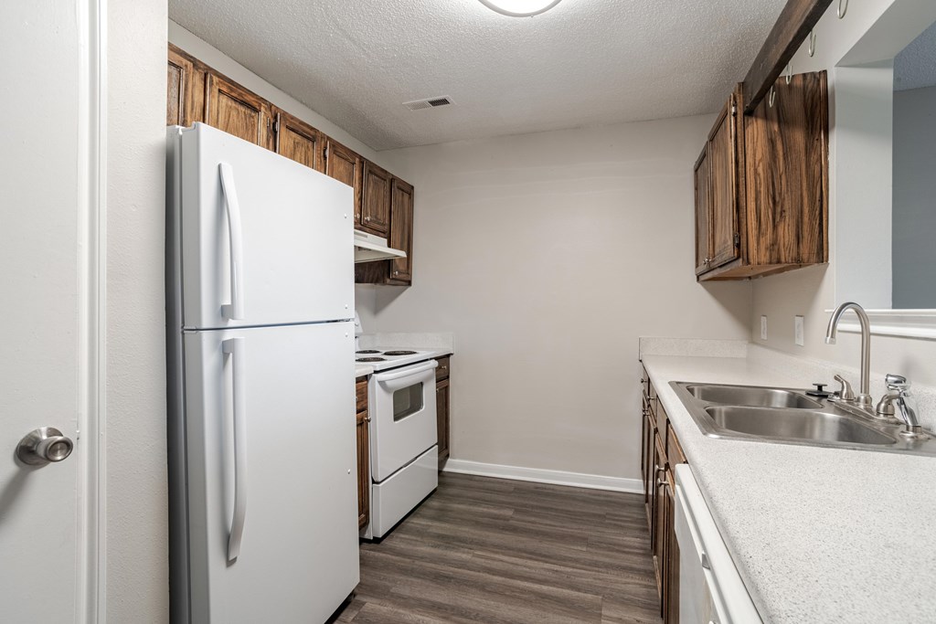 A white refrigerator is in a kitchen with wooden cabinets.