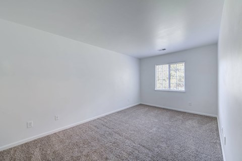 a living room with white walls and a window at Carolina Springs Apartments, 27510