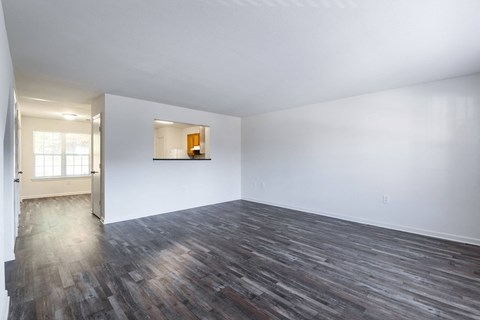 an empty living room with white walls and wood floors at Crescent Pointe Townhomes, Stafford, VA 22554