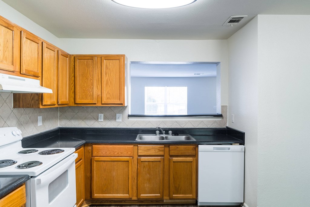 an empty kitchen with white appliances and wooden cabinets at Crescent Pointe, Virginia, 22554